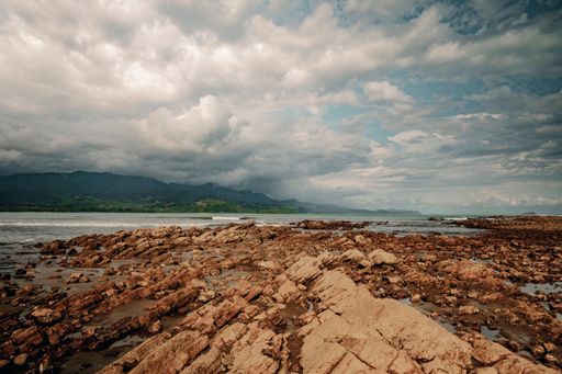 A rocky seabed at low tide or rocky beach at cape Uvita, Costa Rica ,under blue cloudy sky
