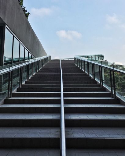 A vertical shot of the stairs of a modern building during the day