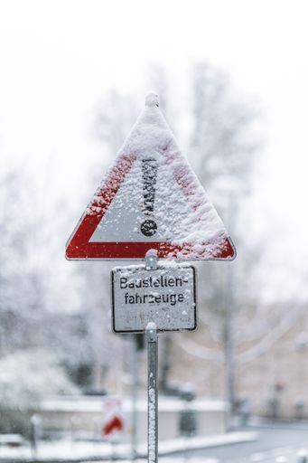 A closeup of a road sign covered in snow
