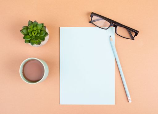Empty paper with a pen, cup of coffee, eyeglasses and a cactus, brainstorming for new ideas, writing a message, taking a break, home office desk