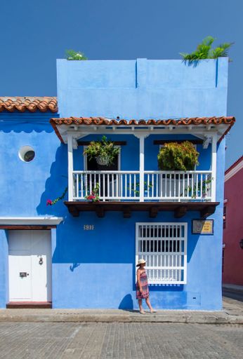 A front view of a beautiful blue house with a balcony