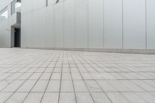 A low-angel shot of an empty ground floor in front of modern architecture exterior.