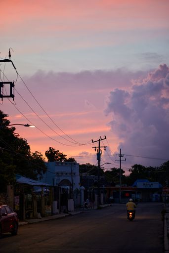A motorbike riding on the street during the pandemic in Tulum, Quintana Roo, Mexico on a sunset
