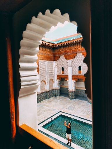 A vertical shot of the architecture man taking a selfie in the Ibn Youssef School, Marrakesh, Morocco