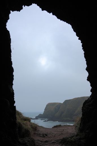 A vertical shot from a cave towards the sea on an overcast day