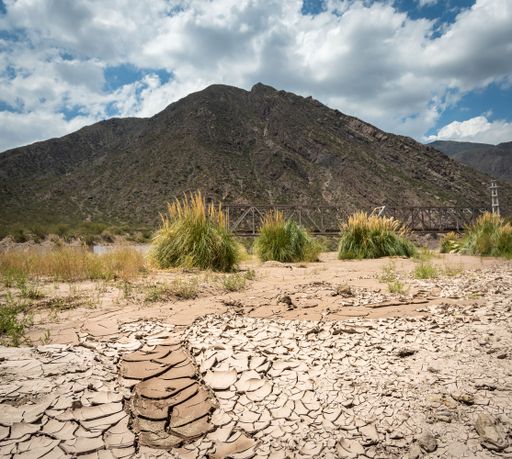 A dry cracked earth near the bridge and mountain of San Rafael de Mendoza river in Argentina