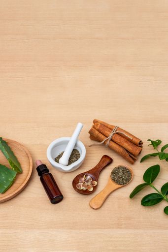 Different alternative medicine herbs, berries on wooden table background