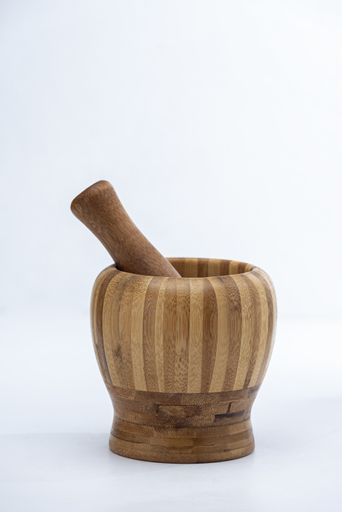 The herb pounding wooden mortar on the white surface