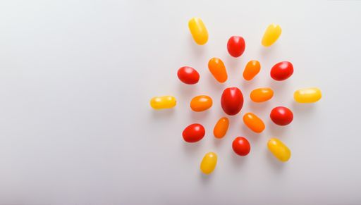 An overhead shot of fresh colorful ripe heirloom tomatoes isolated on a white background