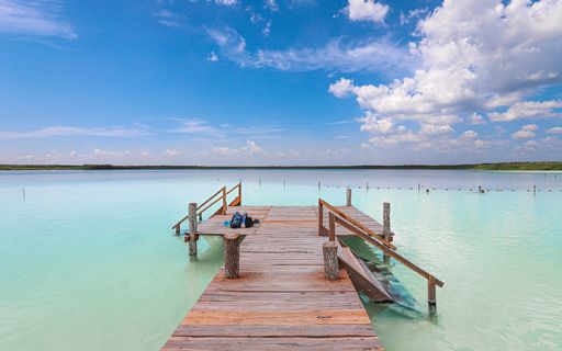 A scenic pier stands above emerald blue waters at Kaan Luum Lagoon.