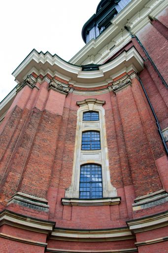 A vertical low angle shot of a red building under the clear sky during daytime
