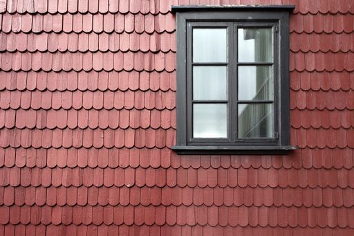 A closeup shot of a wooden window on the clay roof tiles captured at daylight