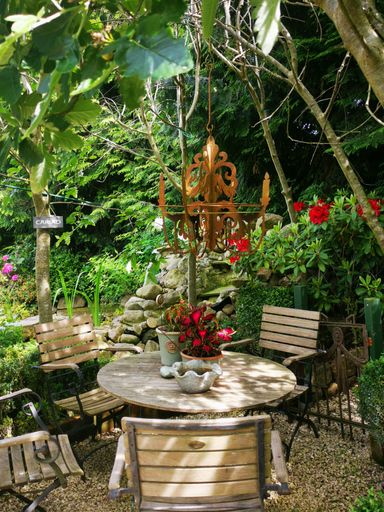 A vertical shot of wooden chairs and table set with decoration in a garden