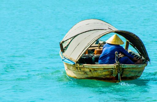 A beautiful shot of a man fishing from an old boat
