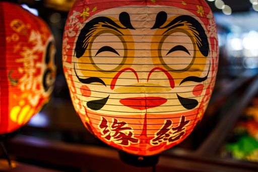 A closeup of a lit oriental lantern with a smiley face in Shanghai, China