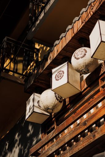 A vertical shot of hanging oriental lanterns on a wooden wall in Shanghai, China