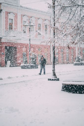 A vertical shot of the man walking down the snowy street of Brcko District. Bosnia and Herzegovina.