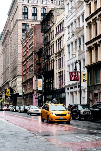 A vertical shot of yellow cabs in urban Manhattan New York on a gloomy day