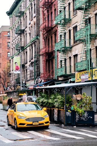A vertical shot of yellow cabs in urban Manhattan New York on a gloomy day