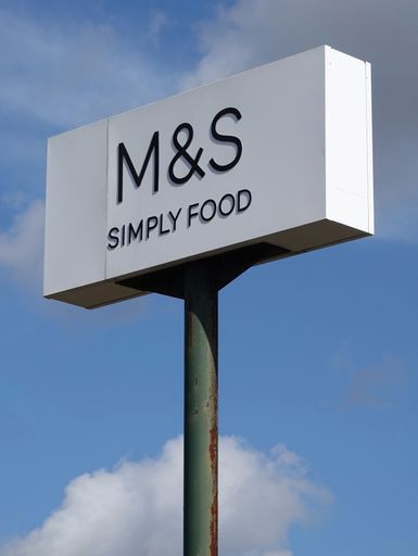A vertical shot of a signboard advertising M and S Simply Food outlet at Peterborough services on the A1 in the UK