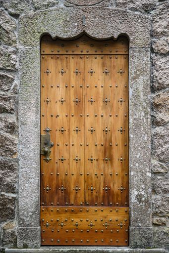 A vertical shot of an old concrete building with a wooden door