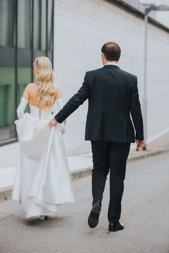 A vertical shot of the bride and groom walking outside