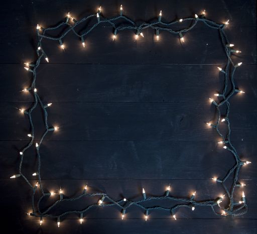 A tree lights frame over a black wooden surface great for background or writing text