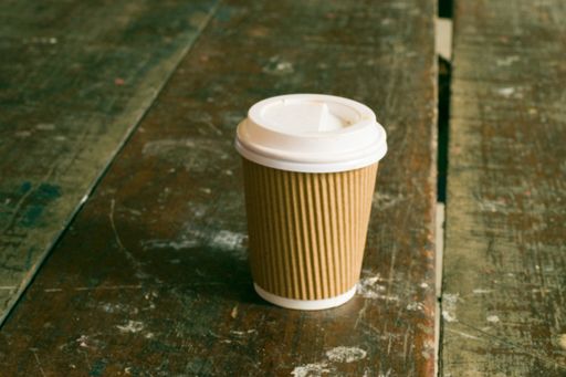 A closeup shot of a disposable cup on a wooden table
