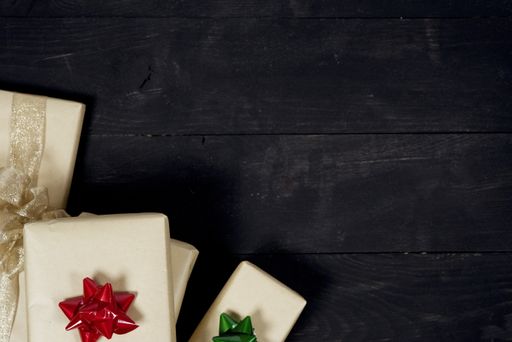 An overhead shot of present on black wooden surface great for writing texts and background
