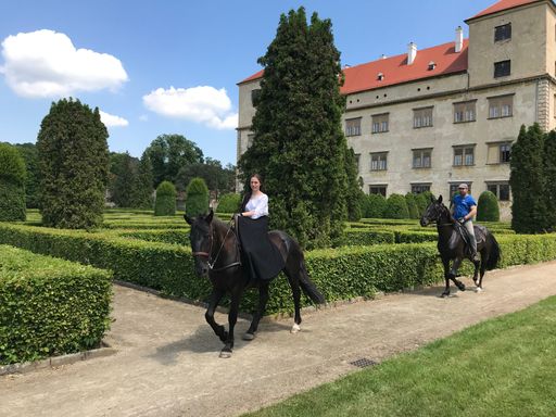 The people horseback riding in a castle yard in Bucovice, Czech Republic