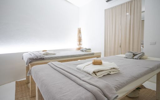 Two massage tables inside a clean modern spa building.