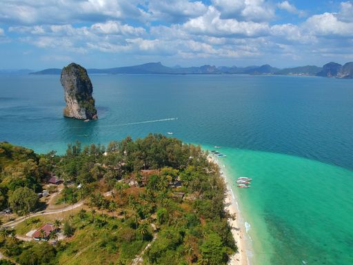 An aerial view of the Poda island seashore with a cloudy sky in the background, in Thailand