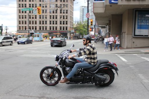 A person riding a motorcycle in downtown Vancouver, British Columbia, Canada
