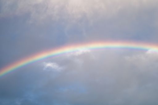 A beautiful shot of a rainbow coming out after the rain in the clear sky