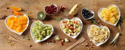 Fruity hearts. Fresh fruits in plates on rustic wooden table. Top view, copy space. Assortment of various fruits on wooden table.