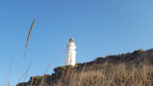 A low angle shot of white lighthouse under blue sky