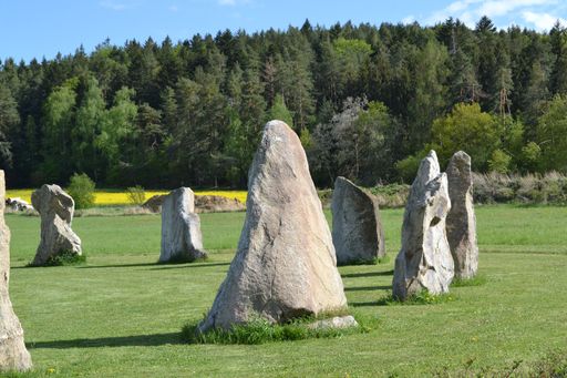 Beautiful view of Stonehenge in historical village Holasovice, Czech Republic. A circle of stones in green field on sunny day. Famous place.