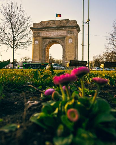 An aerial view of Arch of Triumph under blue bright sky in Bucharest