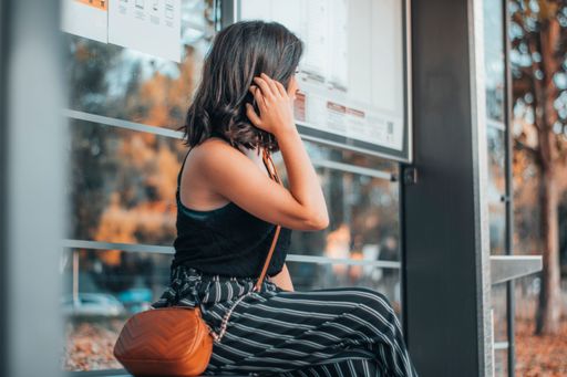 A Caucasian woman sitting at a bus station