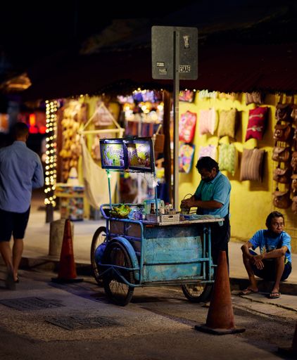 The streets of Tulum, Mexico at night with various street vendors selling clothing and offering food