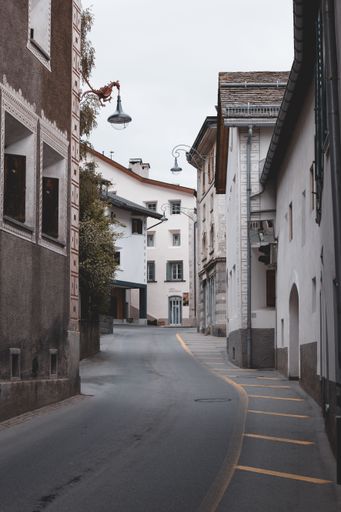 A vertical of a narrow street between residential buildings on a cloudy day