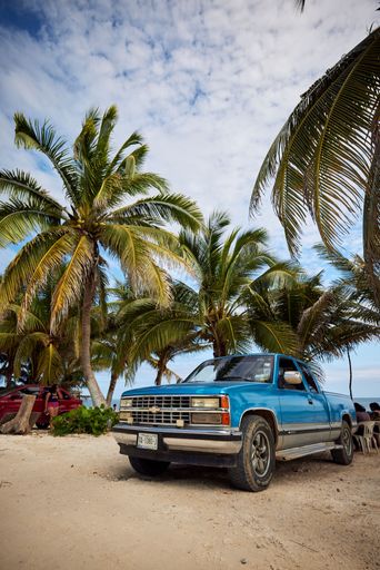 A Chevrolet CK 1500 Truck on the beach with palms in Mahahual, Quintana Roo, Mexico during pandemic