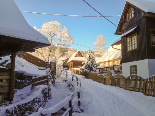 A snowy path through wooden cottages in the mountains of Nizna Boca, Slovakia