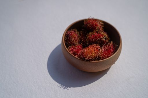 The bowl of fresh rambutan fruit  isolated on white background, close-up