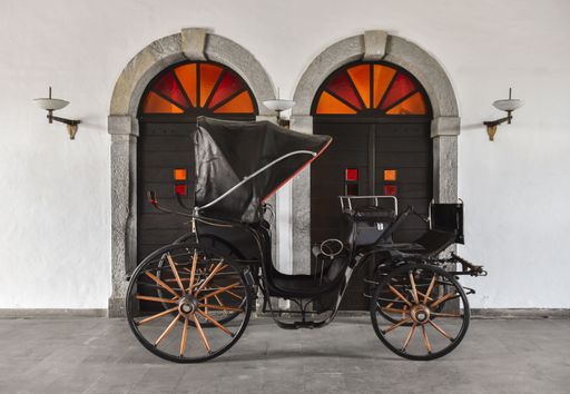 An Old horse carriage parked in courtyard of a castle