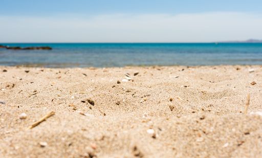 The view of the sand before the sea under the blue sky on a sunny day