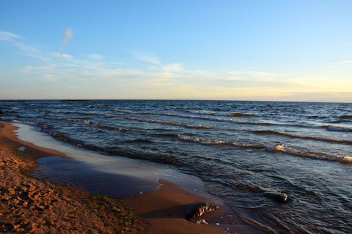 A beautiful shot of a beach with calm sea under cloudy sky during sunset