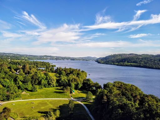 An aerial view of a beautiful lake near the forest in Cumbria, UK
