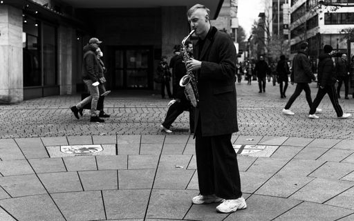 Stuttgart,Germany,November 20,2021:Koenigstrasse A Young street musician was playing the saxophone in the middle of a shopping mile.