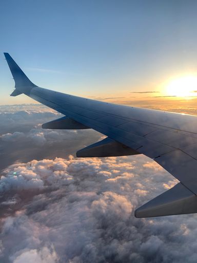 A beautiful shot of a plane wing on the clouds during sunrise